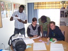 Ollo, Marjo Käyrä, Mamadou Konate ja Leonardo opiskelevat suomen kielen saloja.