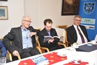 Ralf Mattson ja Pekka Juntunen tutustuvat uuteen kirjaan. Lauri Kauppinen myhäilee vieressä.